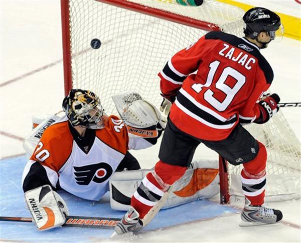 The Devils'  Travis Zajac puts the puck into the net past Philadelphia Flyers goalie Antero Niittymak